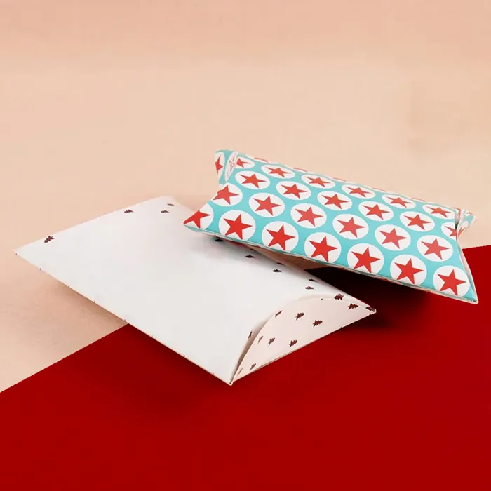 White and red star-patterned pillow boxes, one flat and one assembled, on a red and peach background