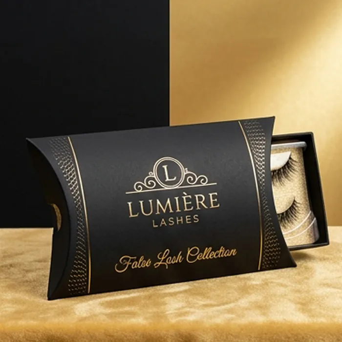 Black false lash pillow box with gold foil lettering on a gold background