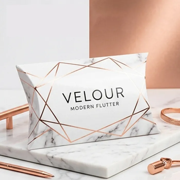 White and rose gold lash pillow box with geometric line work on marble