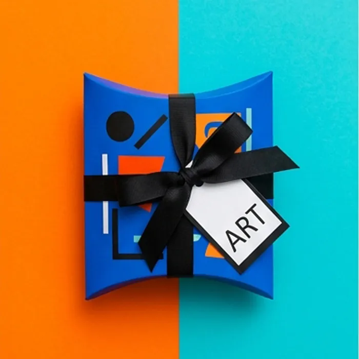 Small blue pillow box with a black bow and a printed art card