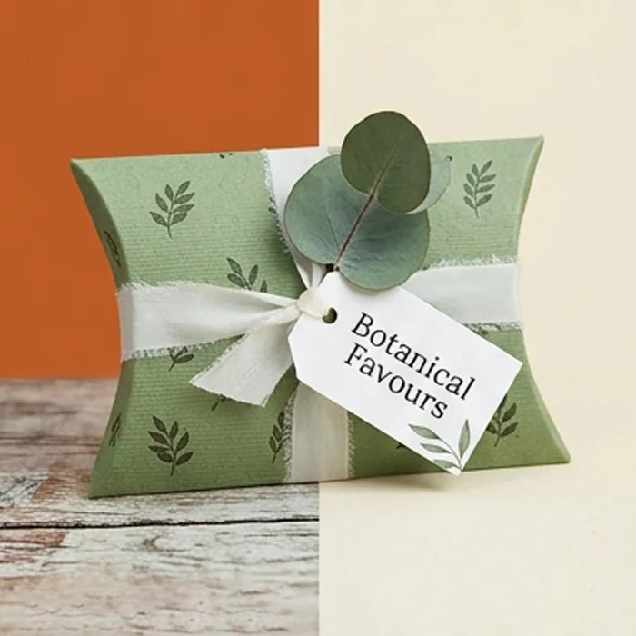 Sage green wedding favor pillow box with a eucalyptus sprig and a botanical tag